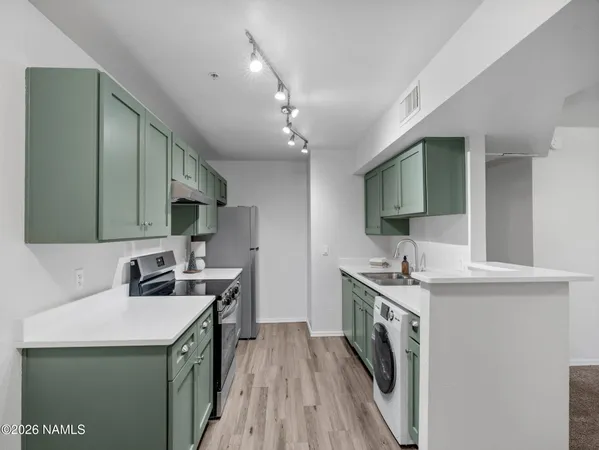 a kitchen that has a sink a stove and a microwave in it