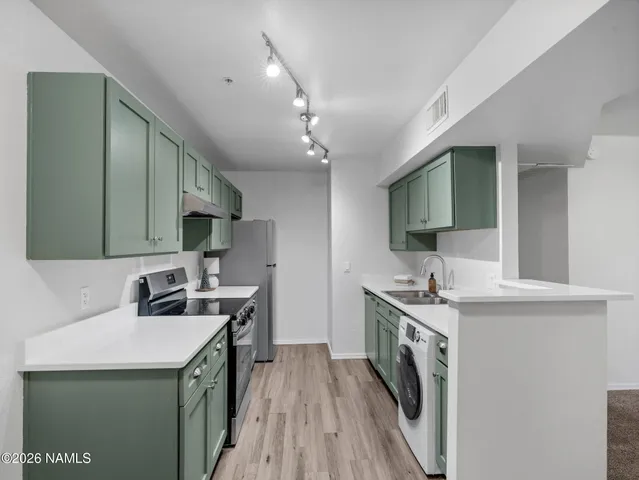 a kitchen that has a sink a stove and a microwave in it