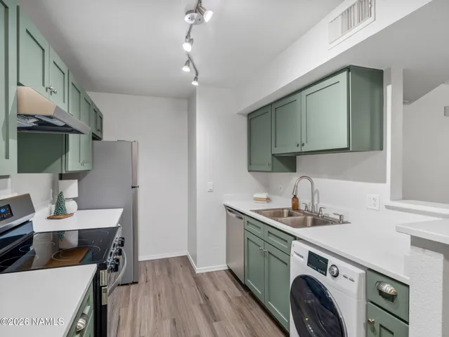 a kitchen with a sink a stove and cabinets