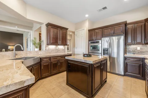 a spacious bedroom with a bed and a flat tv screen on dresser