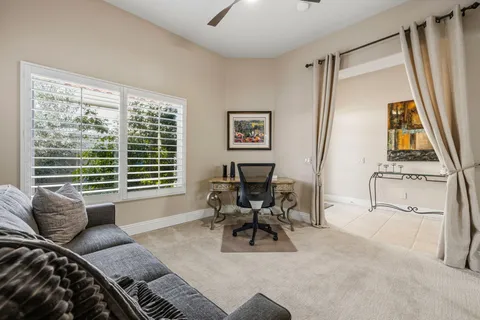 a living room with patio furniture and a potted plant