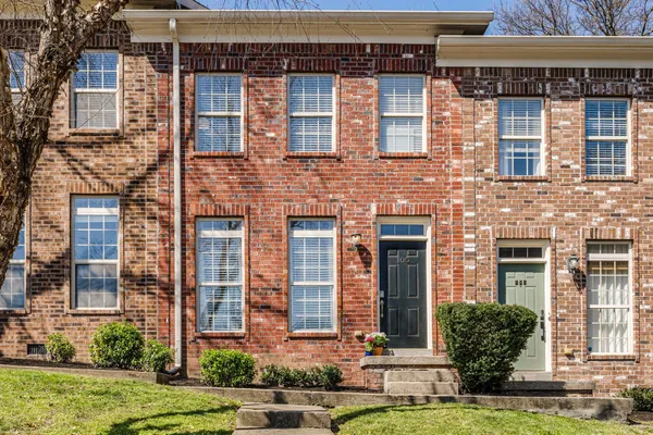 front view of a brick house with a yard