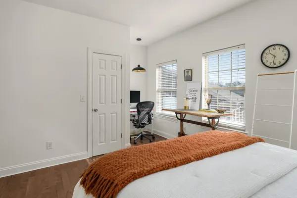 a bedroom with a bed and a table in it with wooden floor
