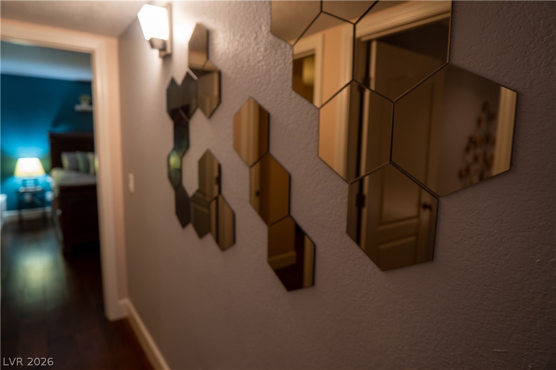9325 West Desert Inn Road, Unit 264 Las Vegas, NV 89117 - Photo 5 of 10 Smooth plaster walls and dark wood flooring define this elegant transition hallway.