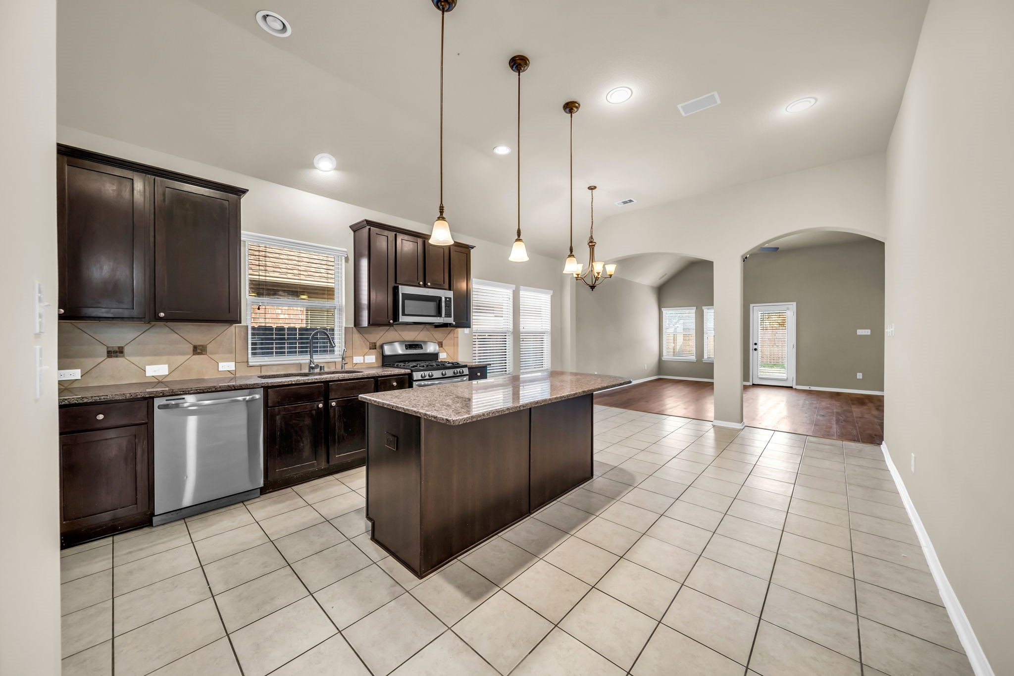 2614 Winding Creek Way Conroe, TX 77385 - Photo 4 of 23 a large kitchen with stainless steel appliances kitchen island granite countertop a sink counter space and cabinets