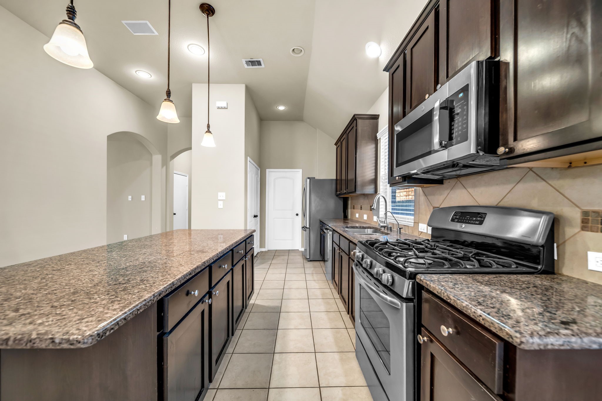 2614 Winding Creek Way Conroe, TX 77385 - Photo 5 of 23 a kitchen with stainless steel appliances granite countertop a stove a sink and a refrigerator