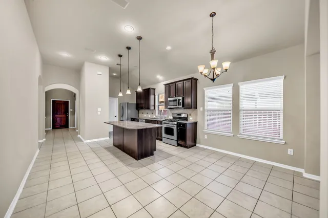 a kitchen with stainless steel appliances kitchen island granite countertop a sink and cabinets