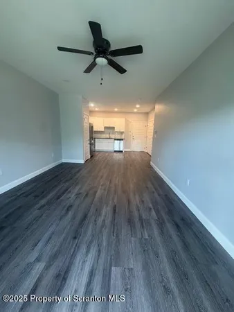 a view of a big room with wooden floor wooden floor and windows