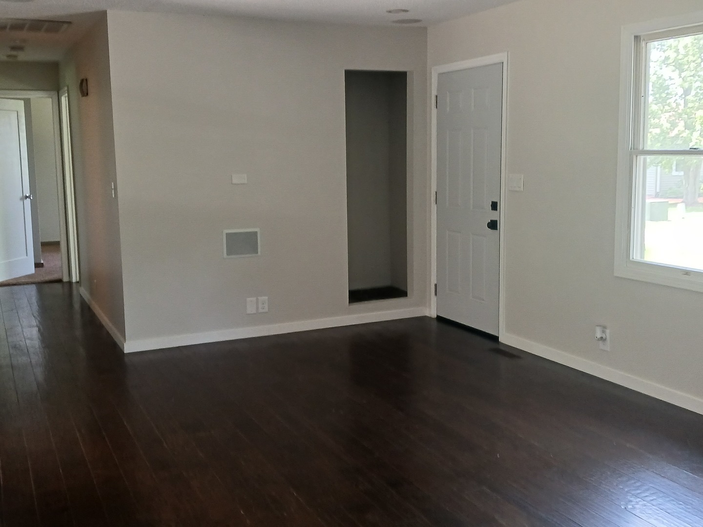9 Southview Drive Sidney, IL 61877 - Photo 3 of 21 an empty room with wooden floor and windows with curtains