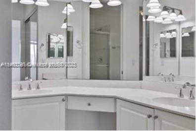 3600 Oaks Clubhouse Drive, Unit 509 Pompano Beach, FL 33069 - Photo 13 of 22 a bathroom with a sink vanity and a mirror
