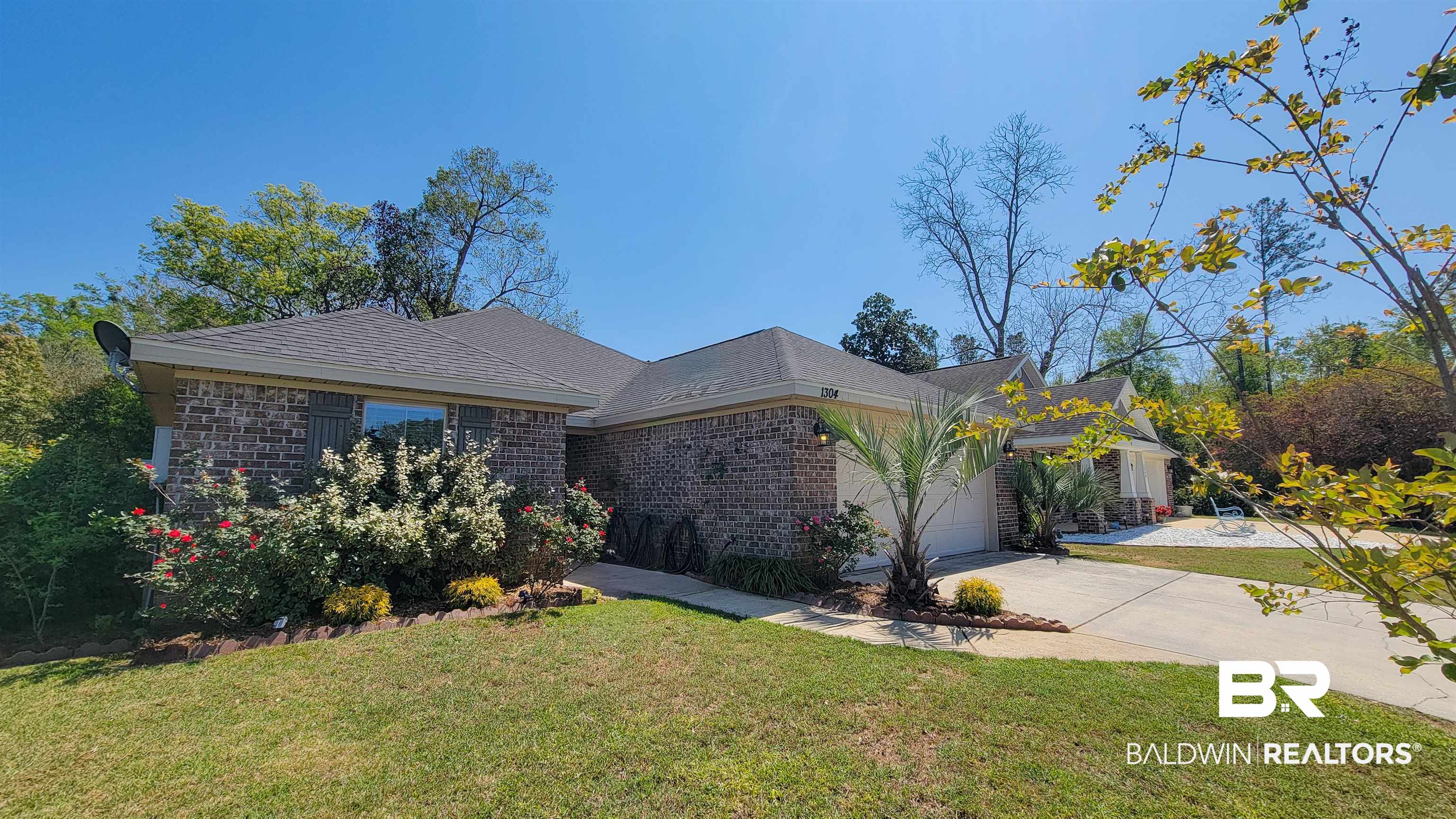 1304 Majesty Loop Foley, AL 36535 - Photo 35 of 44 View of front facade with brick siding, a front yard, a garage, and concrete driveway