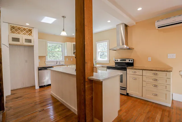 a kitchen with white cabinets and appliances