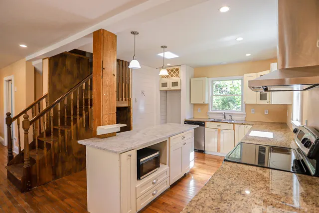 a kitchen with stainless steel appliances granite countertop a stove a sink and a refrigerator