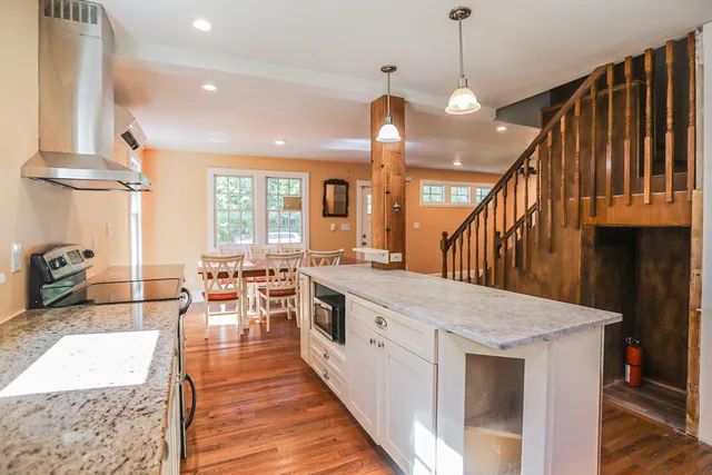 a large kitchen with lots of counter space a sink a dining table and chairs