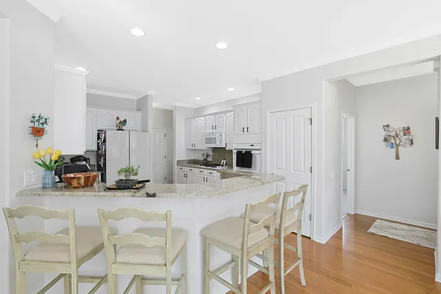 a kitchen with stainless steel appliances kitchen island granite countertop a table and chairs in it