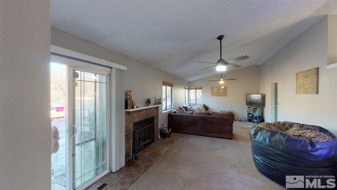 285 Gooseberry Drive Reno, NV 89523 - Photo 7 of 24 a living room with furniture a chandelier and a fireplace