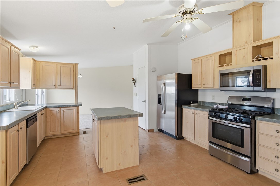 4619 North Lookout Canyon Road Kingman, AZ 86401 - Photo 13 of 50 a kitchen with stainless steel appliances a stove a sink and a refrigerator