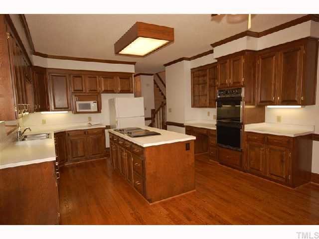 602 Neodak Road Apex, NC 27523 - Photo 8 of 12 Raised panel cabinets with built-in desk area add warmth to this wonderful country kitchen. Don't miss the back stairs!