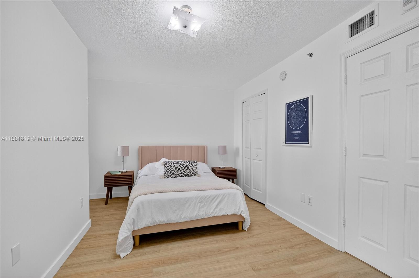 2475 Northwest 16th St Road, Unit 308 Miami, FL 33125 - Photo 12 of 25 a bedroom with a bed and wooden floor