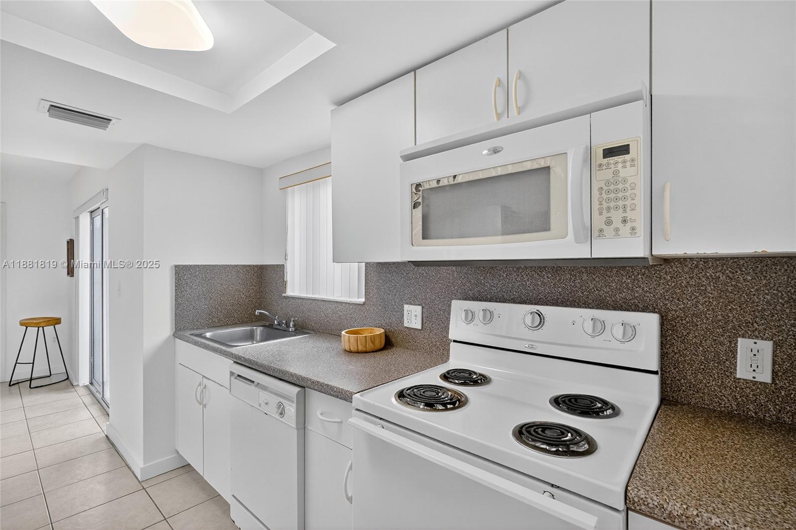 2475 Northwest 16th St Road, Unit 308 Miami, FL 33125 - Photo 16 of 25 a kitchen with cabinets and appliances