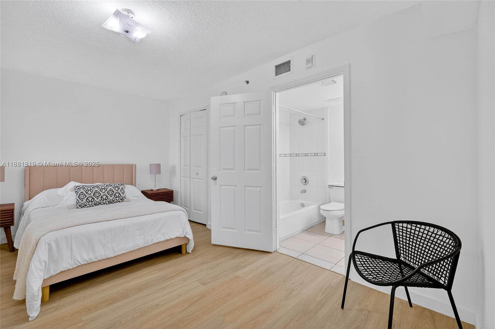 2475 Northwest 16th St Road, Unit 308 Miami, FL 33125 - Photo 18 of 25 a bedroom with a bed and a chair