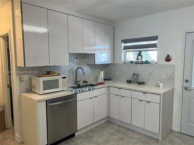 a kitchen with cabinets appliances a sink and a window