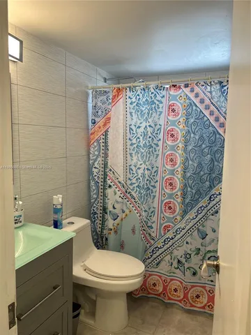 a bathroom with a toilet and shower curtain
