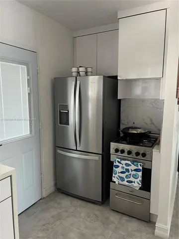 a metallic refrigerator freezer sitting in a kitchen