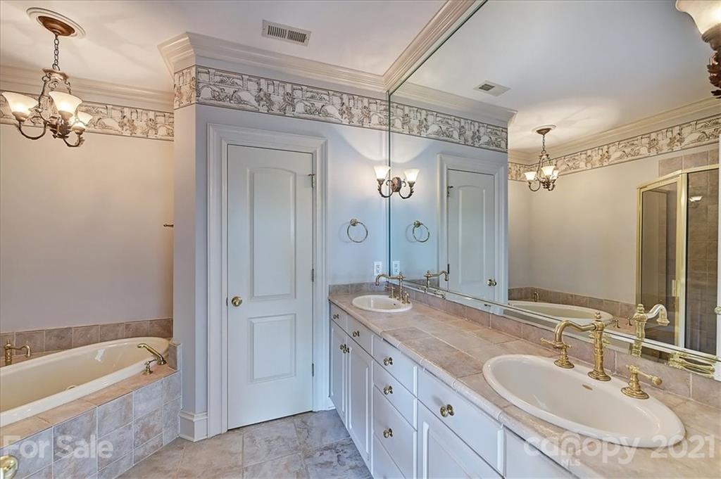 17519 Jetton Road, Unit 390 Cornelius, NC 28031 - Photo 20 of 31 a bathroom with a granite countertop tub a double vanity sink and mirror