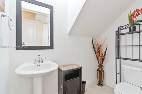 a bathroom with a sink toilet and a mirror