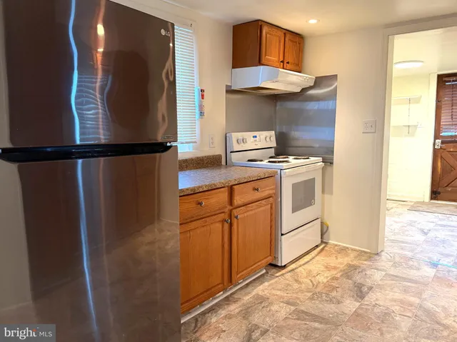 a kitchen with a refrigerator a stove and a sink