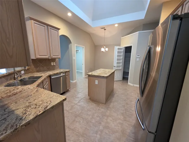 a kitchen with stainless steel appliances granite countertop sink stove refrigerator and cabinets