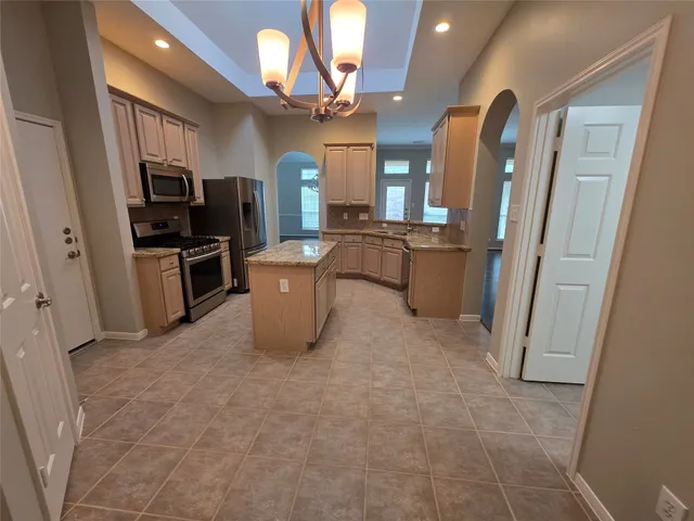 a large kitchen with a refrigerator a stove top oven a sink and dishwasher