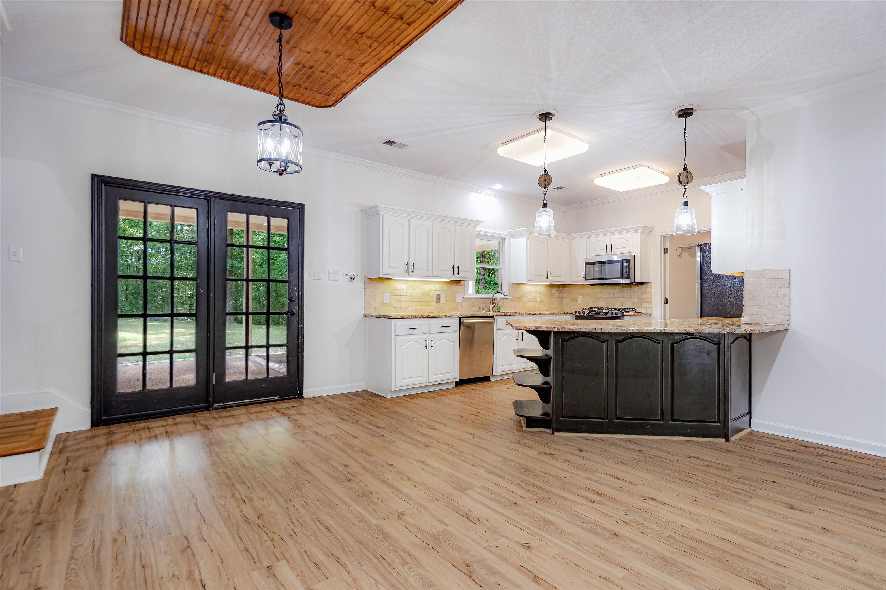 4020 Price Road Moscow, TN 38057 - Photo 11 of 35 Kitchen with light wood finished floors, stainless steel appliances, baseboards, white cabinetry, and decorative backsplash