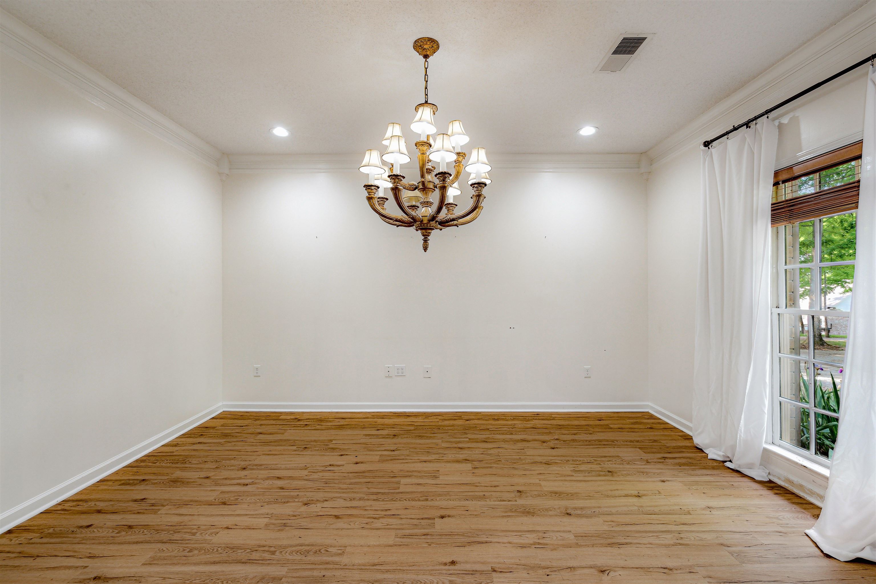 4020 Price Road Moscow, TN 38057 - Photo 17 of 35 Empty room with crown molding, a chandelier, and light wood finished floors