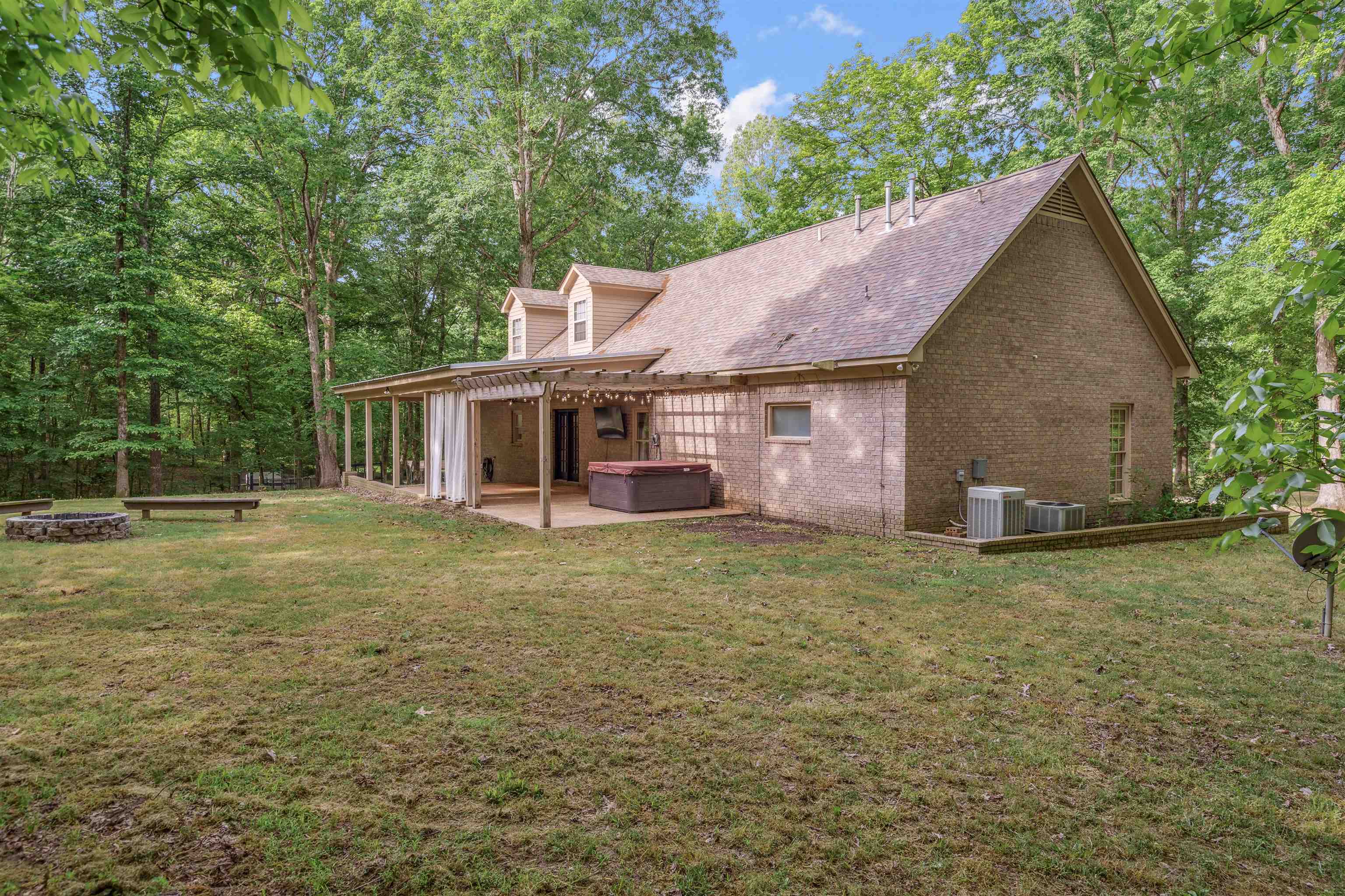 4020 Price Road Moscow, TN 38057 - Photo 33 of 35 Rear view of property featuring an outdoor fire pit, a patio, brick siding, a lawn, and a hot tub