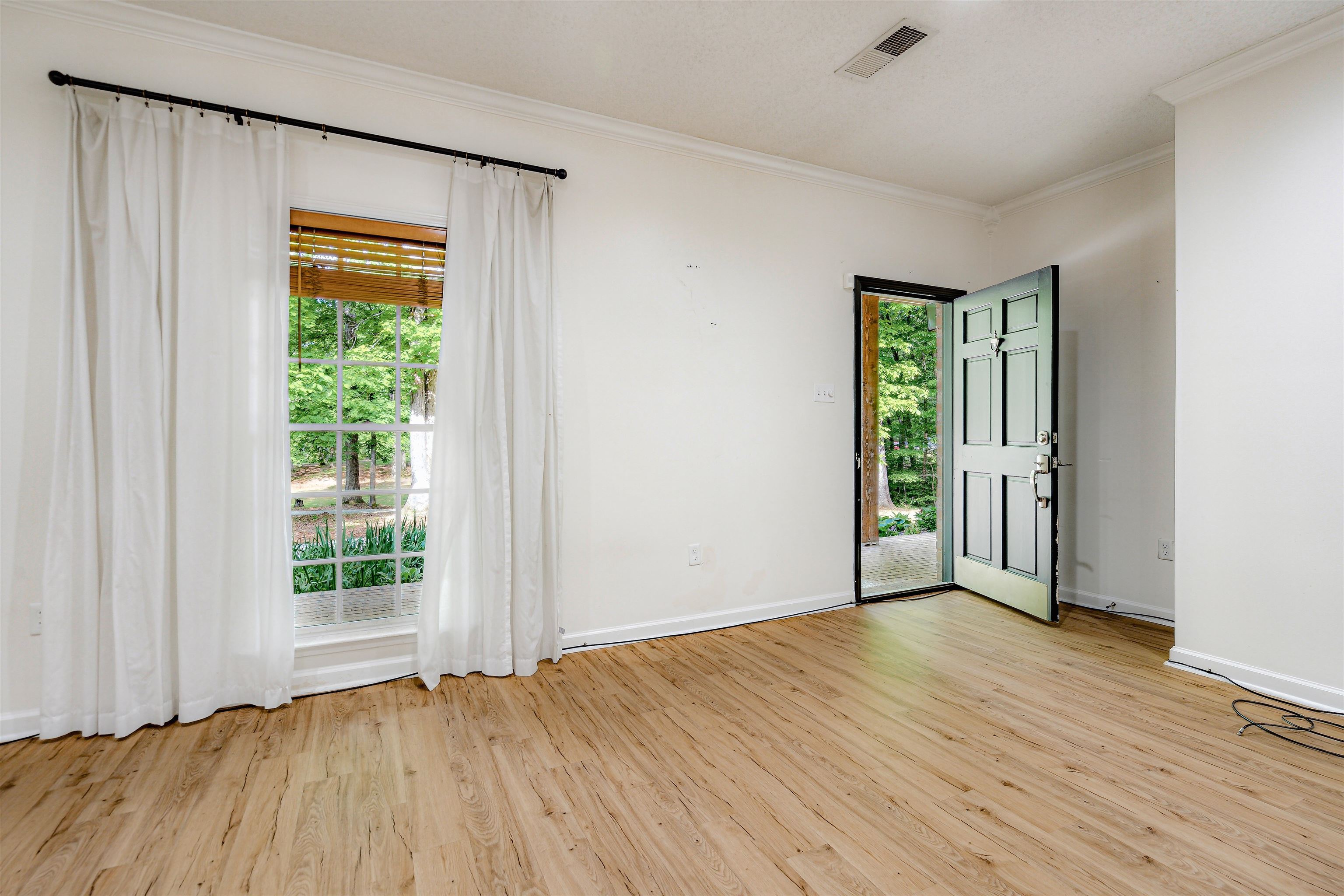 4020 Price Road Moscow, TN 38057 - Photo 7 of 35 Spare room featuring plenty of natural light, baseboards, ornamental molding, and light wood-type flooring