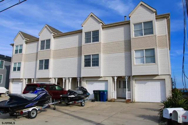 a front view of a house with cars parked
