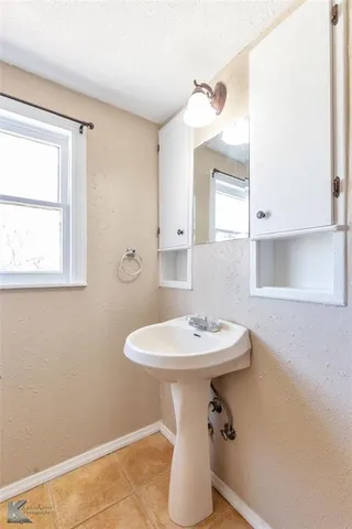 a bathroom with a sink a toilet and mirror