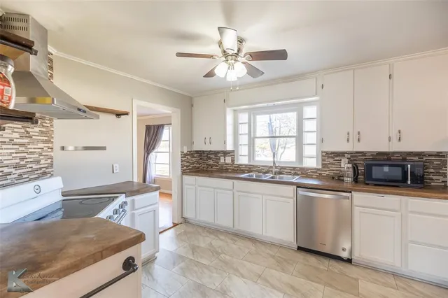 a kitchen with granite countertop cabinets stainless steel appliances a sink and a window