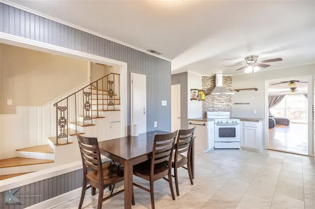 a dining area with a table chairs and a kitchen view