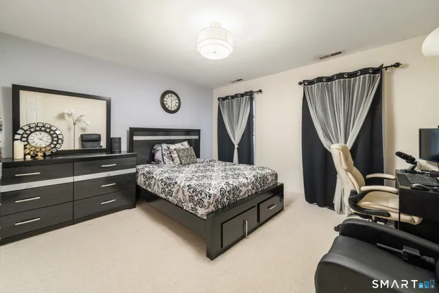 a bedroom with a bed and a flat tv screen on dresser
