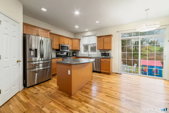 a kitchen with stainless steel appliances granite countertop a refrigerator a stove top oven a sink and dishwasher