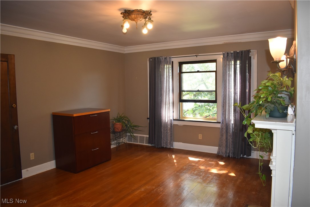 4581 Pearl Road Cleveland, OH 44109 - Photo 13 of 36 Spare room featuring dark wood finished floors and ornamental molding
