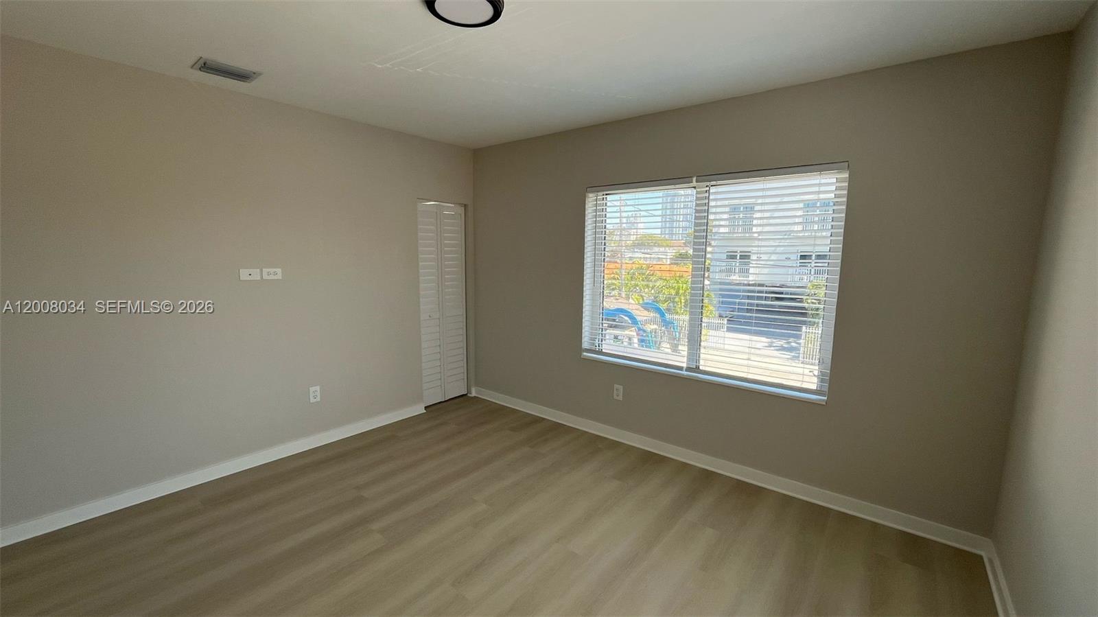 534 Southwest 6th Court, Unit 1 Miami, FL 33130 - Photo 7 of 10 an empty room with wooden floor and windows