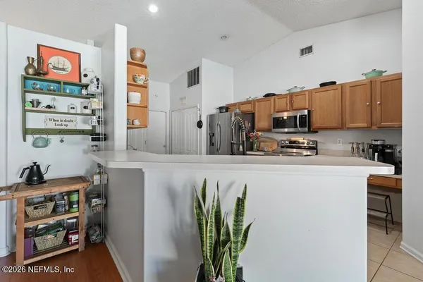 a kitchen with stainless steel appliances a refrigerator and a stove top oven