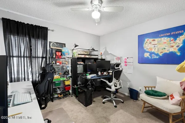 a view of a workspace with furniture and a window