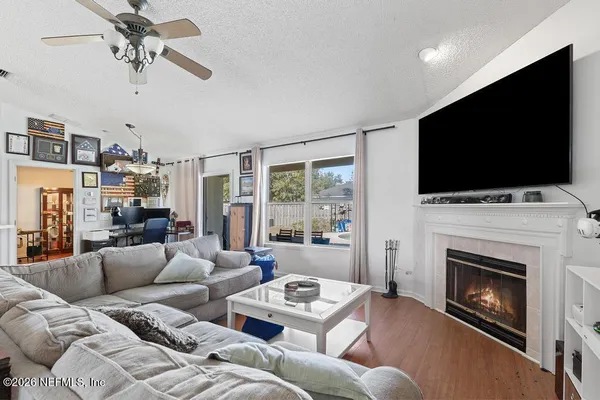 a living room with furniture a flat screen tv and a fireplace