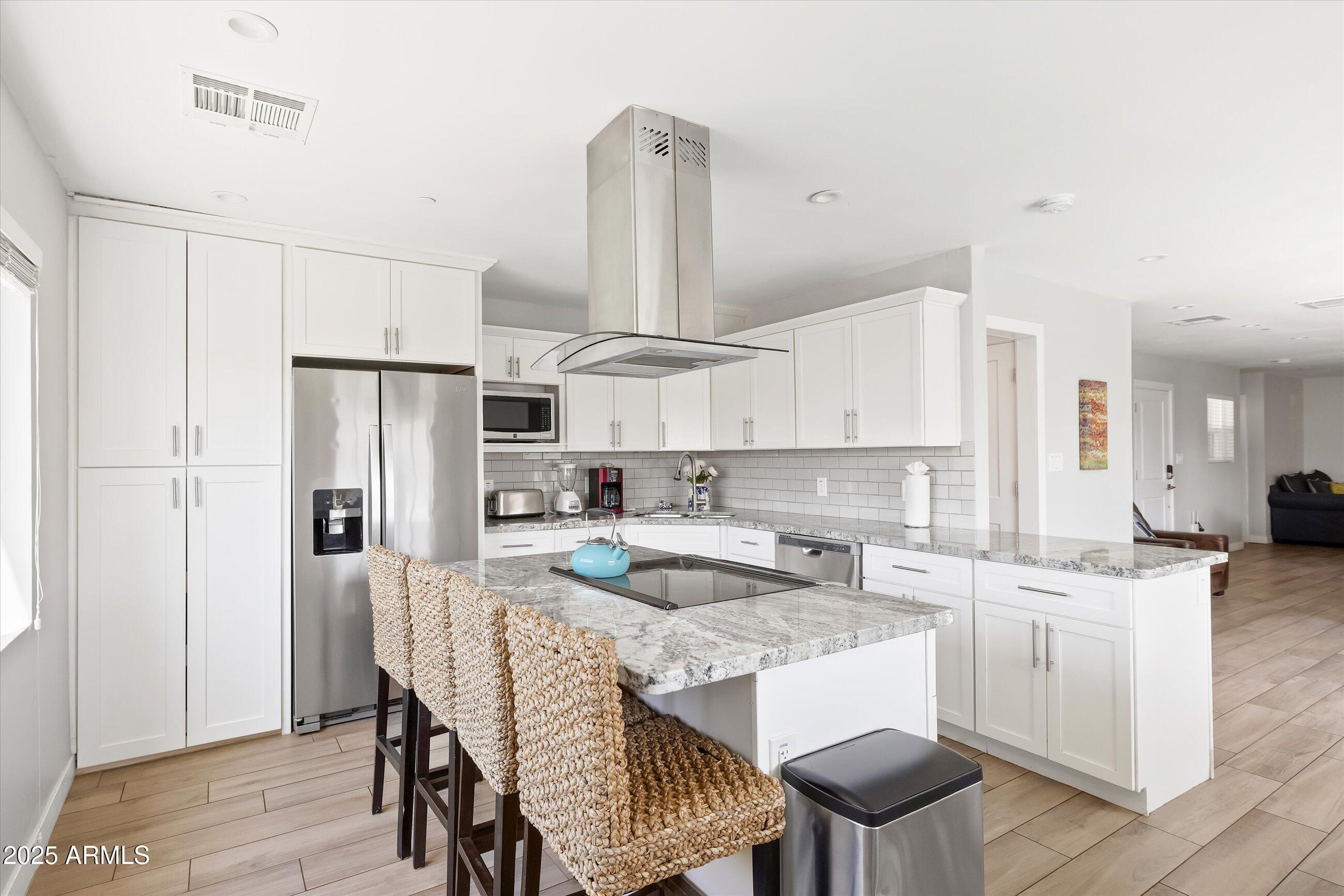 8201 East Piccadilly Road Scottsdale, AZ 85251 - Photo 12 of 26 a kitchen with refrigerator cabinets and wooden floor