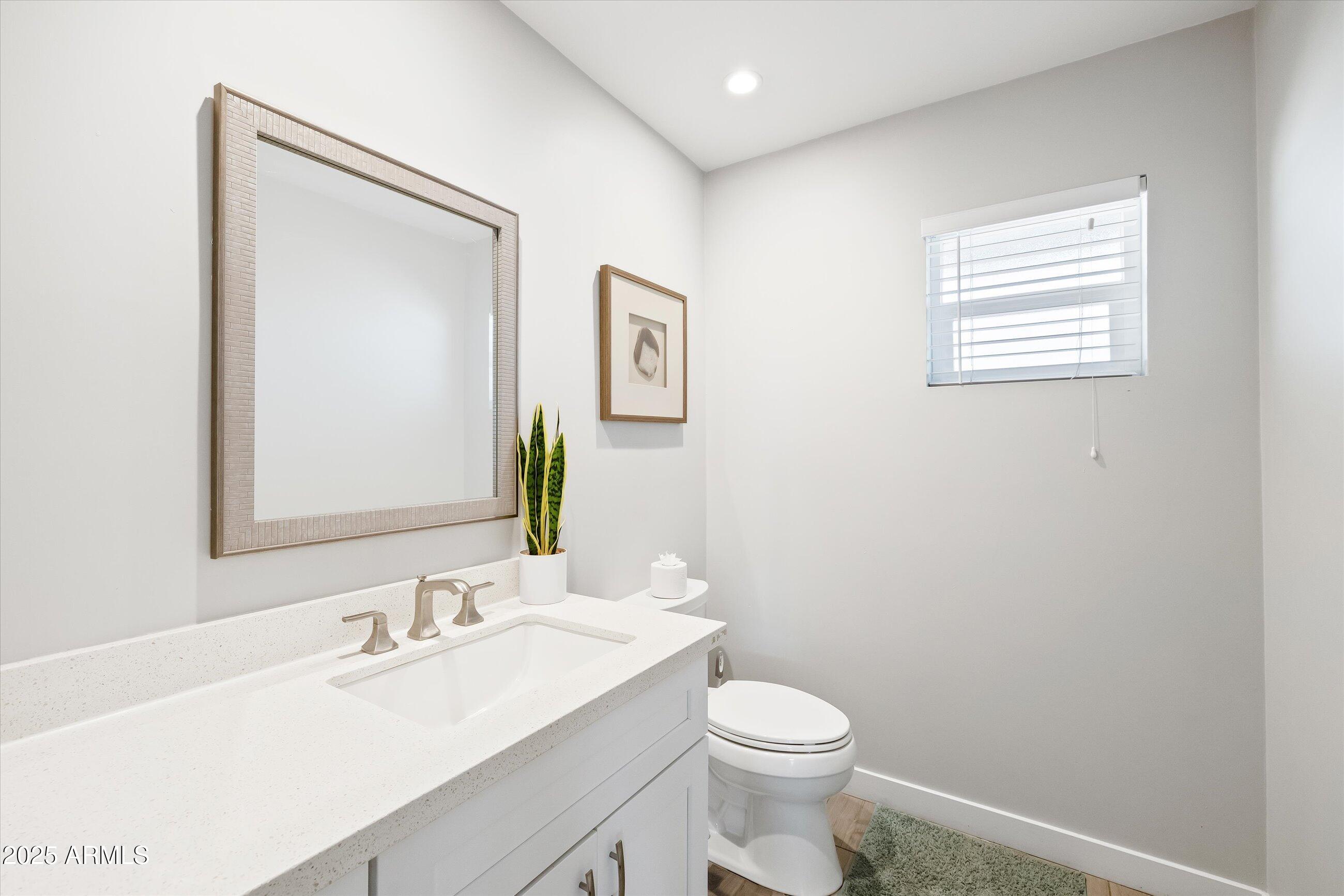 8201 East Piccadilly Road Scottsdale, AZ 85251 - Photo 14 of 26 a bathroom with a toilet a sink a vanity and mirror